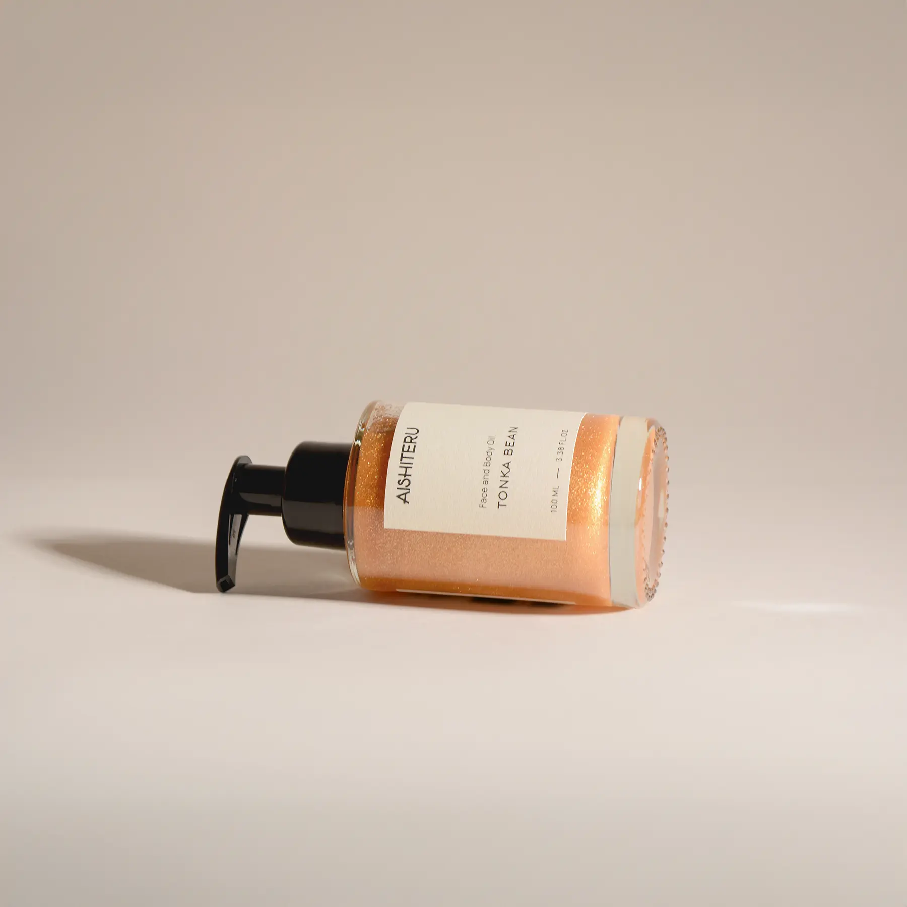 Flacon en verre contenant l’huile nacrée AISHITERU avec étiquette minimaliste, 100 ml